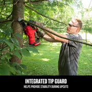 Photo of person using Craftsman cordless chainsaw CMCCS320D1 to cut tree branch outdoors, demonstrating tip guard feature.