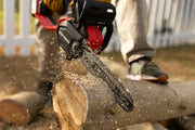 Photo of Craftsman CMCCS630P1 cordless chainsaw cutting a log outdoors, visible red and black body and battery.