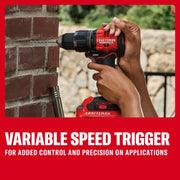 A person uses a CRAFTSMAN cordless drill to drill into a brick wall. The image highlights the tool's variable speed trigger for added control and precision. The drill is red and black, and the scene includes a close-up of hands operating the tool.