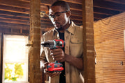 Photo of person using Craftsman cordless drill CMCD732D2 in a wood-framed room under construction.
