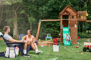 Photo of CRAFTSMAN CMCE003B portable fan on a bucket in a backyard. Wooden playset and people are visible in background.