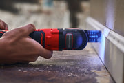 Photo of CRAFTSMAN brushless cordless oscillating tool CMCE565B cutting trim, handheld in use.