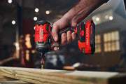Photo of Craftsman cordless impact driver SKU CMCF813C2 in use on wood, red and black body, close-up view.