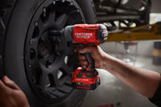 Photo of a Craftsman cordless impact wrench, SKU CMCF940M1, being used on a black vehicle wheel.