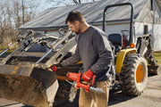 Photo of CRAFTSMAN cordless grease gun CMCGG001D1 used to lubricate excavator bucket outdoors.