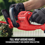 Close-up photo of Craftsman hedge trimmer CMCHT810C1, red body with full wrap around handle, being used on hedges.