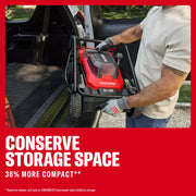 Photo of a person loading a folded Craftsman lawn mower CMCMWP120M2 into a vehicle trunk, highlighting compact storage.