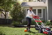 Photo of Craftsman lawn mower CMCMWSP320X2 in use on grass by a house, visible orange basketball in foreground.