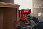 Photo of Craftsman cordless nailer CMCN623C1 in use on wood furniture, showing red and black tool design.