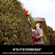 Craftsman pole hedge trimmer CMCPHT818D1 used to cut tall bushes outdoors.