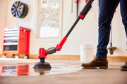 Photo of Craftsman CMCPS520D1 power scrubber cleaning wet garage floor, red and black tool in use.
