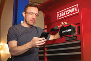 Photo of person using a mobile phone near a red CRAFTSMAN speaker, model CMCR001B, on a red tool chest.