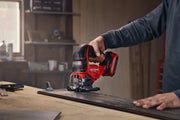Photo of Craftsman cordless jigsaw CMCS650B cutting wood in a workshop, close-up of tool in use.