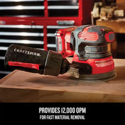 Photo of CRAFTSMAN cordless random orbital sander CMCW220B on wood, red and black finish, workshop background.