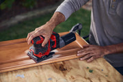 Photo of Craftsman CMCW222B cordless sander in use, sanding a wooden cabinet door on a workbench outdoors.