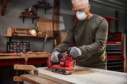 Person using CRAFTSMAN CMCW223B cordless belt sander on wood surface in workshop, photo shows tool in action.
