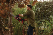 Photo of Craftsman CMECS600 corded chainsaw cutting tree branch outdoors, person wearing gloves and ear protection.
