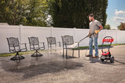 Photo of Craftsman CMEPW1900 pressure washer cleaning outdoor metal chairs on driveway.