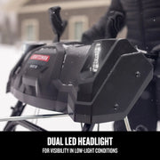 Craftsman snow blower CMGB223101 close-up showing dual LED headlights in snowy outdoor setting.