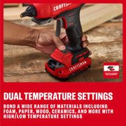 Photo of Craftsman cordless hot glue gun CMGL200B on a wooden surface, hand holding handle, close-up side angle.