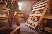 Photo of Craftsman CMHT82501 pry bar being used in a workshop, with wooden pallets and tool storage visible.