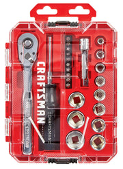 A clear plastic case containing a Craftsman ratchet and socket set. The set includes a ratchet handle, screwdriver handle, various screwdriver bits, several sockets in different sizes, a socket extension, and other small components, all arranged neatly in individual compartments. The interior is red with the Craftsman brand name visible.