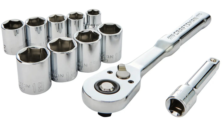 A set of shiny chrome socket wrenches, including a ratchet handle, an extension bar, and multiple socket heads of various sizes. The tools are arranged on a white background.
