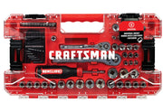 A red and transparent Craftsman tool set case containing a variety of sockets, a ratchet, multiple bits, hex keys, and a screwdriver. The case displays the Craftsman brand prominently in the center and includes a label indicating a universal socket that works with five different fasteners.