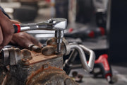 Photo of Craftsman ratchet tool in use on rusty machinery, close-up, SKU CMMT86324V, hand gripping handle.