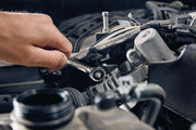 Photo of Craftsman ratchet wrench CMMT87025 used on a car engine, close-up of tool in action.