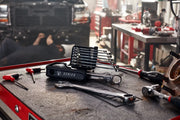Photo of CRAFTSMAN wrench set CMMT87300V on a workbench in a garage with other hand tools visible.