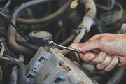Photo of CRAFTSMAN CMMT87707 wrench in hand tightening bolt on engine part.