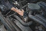 Photo of a hand using Craftsman ratcheting wrench, SKU CMMT87711, on a car engine component.