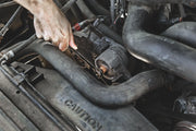 Photo of CRAFTSMAN wrench in use on engine part, SKU CMMT87711, automotive repair context.