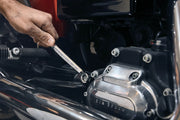 Photo of a hand using a CRAFTSMAN wrench, SKU CMMT99333, to tighten a bolt on a motorcycle engine.