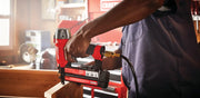 Photo of Craftsman CMPBN18K brad nailer in use, red and black tool attached to air hose, woodworking scene.