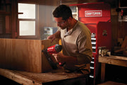 Person using a Craftsman CMPFN16K finish nailer on a wooden box in a workshop, red Craftsman tool chest in background.