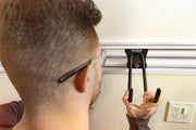 Close-up photo of a person installing a Craftsman wall hook on a rail system, SKU CMST22000, garage organization accessory.