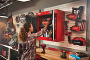 Person organizing power tools in red Craftsman wall cabinet CMST22800RB in a workshop with matching tools and accessories.