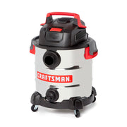 A stainless steel wet/dry vacuum cleaner with black and red accents, labeled 'CRAFTSMAN' on the front. The vacuum features a large canister, wheels for mobility, and multiple hose connections.