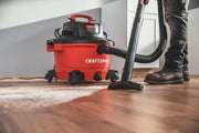 Photo of a Craftsman wet/dry vacuum CMXEVBE17594 in use on a hardwood floor, cleaning debris with floor nozzle.