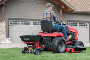 Photo of Craftsman lawn tractor with rear attachment, SKU CMXGZBF7124322, on grass in residential setting.