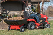 Photo of Craftsman lawn tractor towing dump cart, SKU CMXGZBF7124489, filled with mulch in a residential yard.