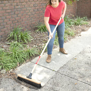 Photo of Craftsman outdoor broom CMXMLBA7218A sweeping dirt on a sidewalk.