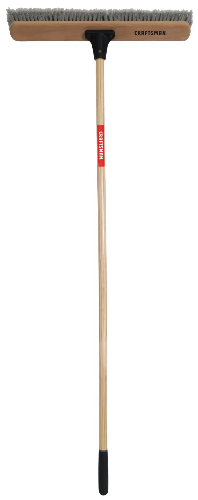 Photo of Craftsman push broom CMXMLBA8224A with wooden handle, wide brush head, and gray bristles, front angle.