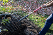 Craftsman CMXMLTP35326 garden rake with wooden handle used for soil in outdoor setting.