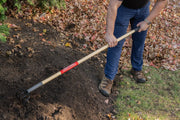 Photo of a Craftsman garden cultivator SKU CMXMLTP35328 with wood handle in use on soil outdoors.