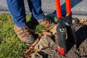 Photo of Craftsman post hole digger CMXMLTP35333 in use on soil near rocks and grass.