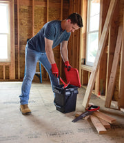 Person wearing red Craftsman gloves using a Craftsman black and red utility bucket, SKU CMXXPBP5GP, in a construction setting.