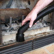 Photo of CRAFTSMAN CMXZVBE38725 vacuum brush cleaning fireplace ash, black flexible hose, close-up view.
